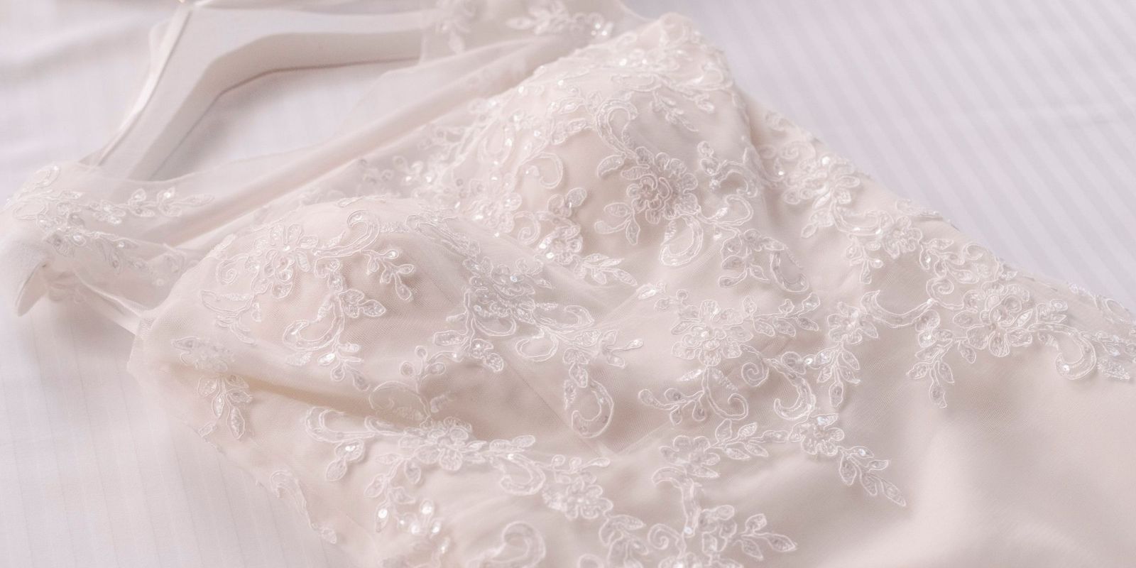 A close-up of a lace wedding dress on a hanger | Source: Pexels