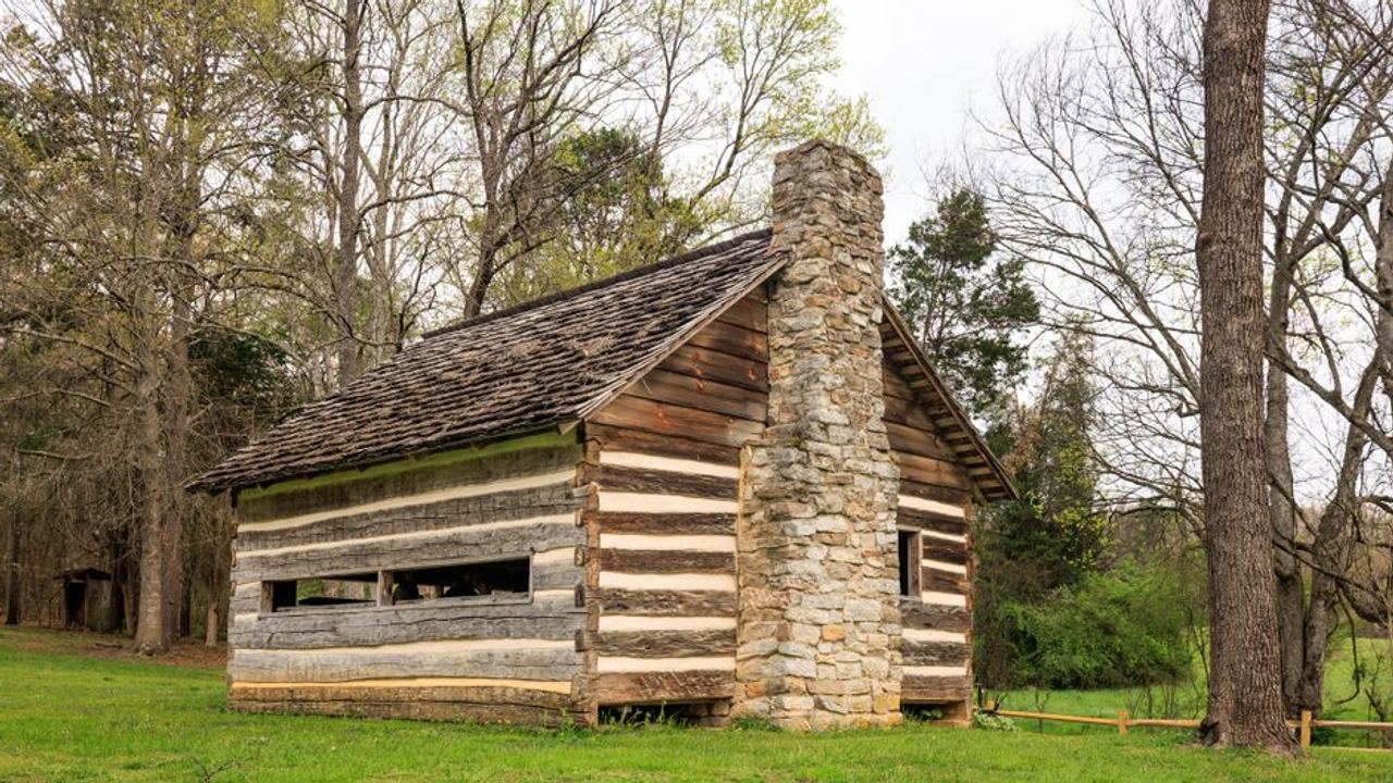 Charming historic log cabin surrounded by lush trees in Maryville, Tennessee.
