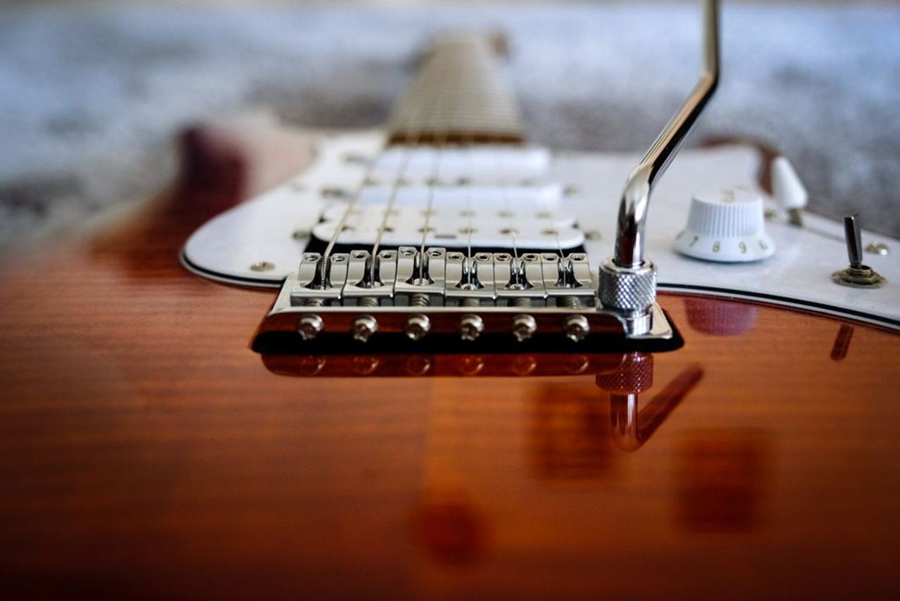 Detailed close-up of an electric guitar highlighting its strings and body.