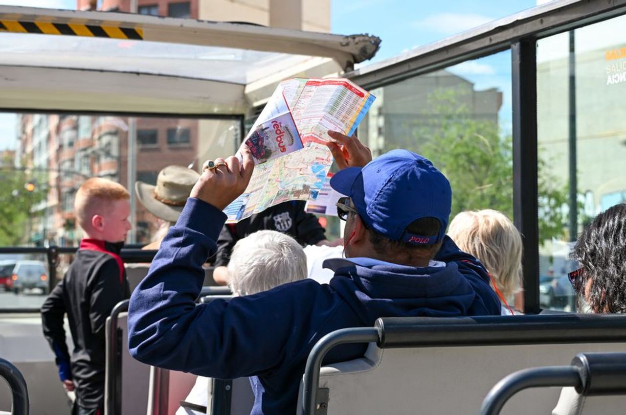 Tourists explore Valencia on an open-top bus tour, highlighting city sights and attractions.